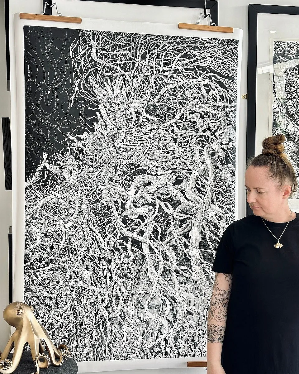 Aga Kubish standing beside Habitat hung from battens, the printed sheet running from above her head to below her waist.