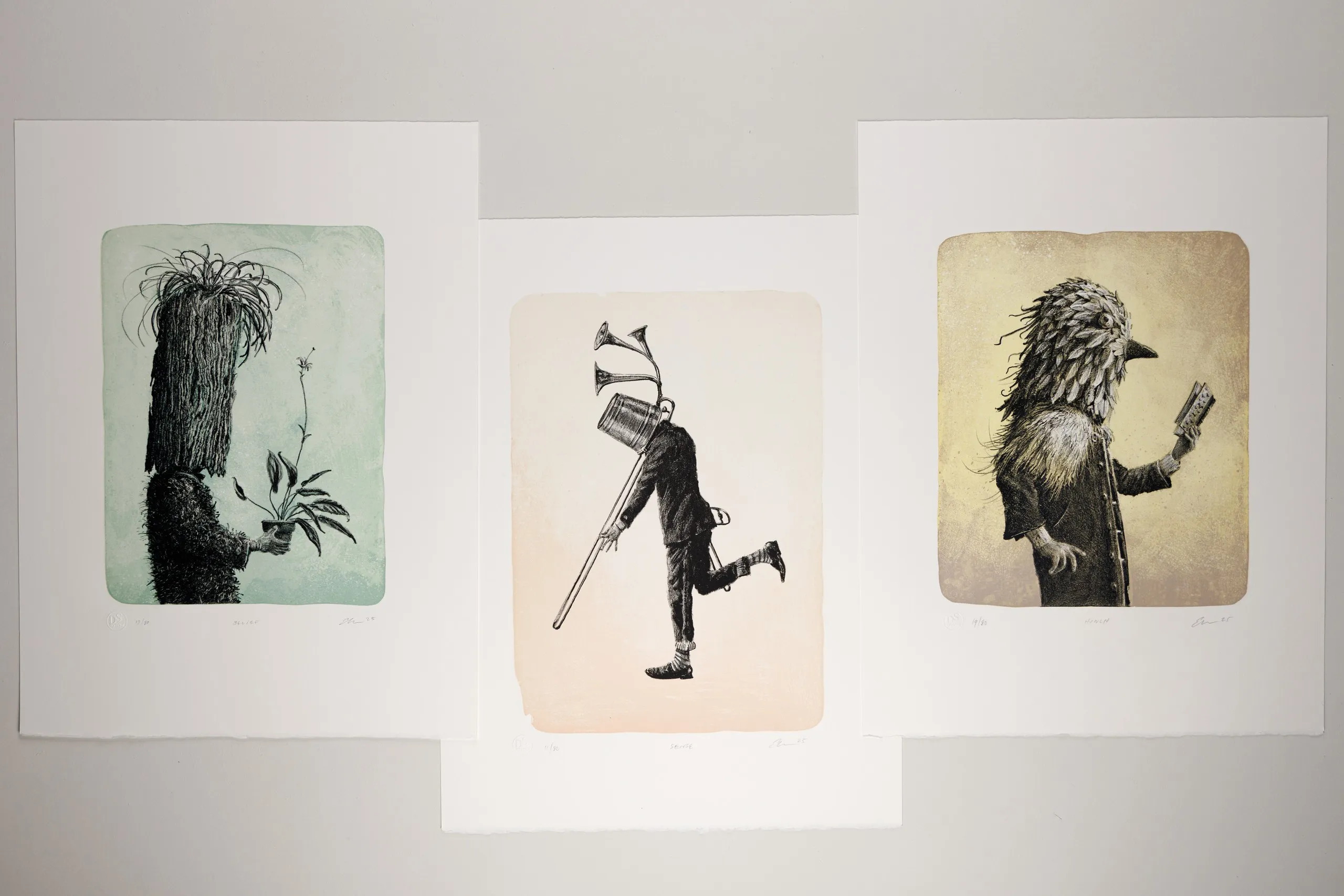 Three stone lithographs by Ethan Murrow displayed together, each a solitary figure.